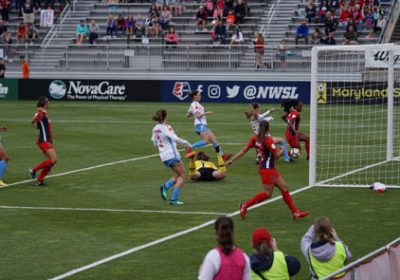 A group of people playing soccer on a field.