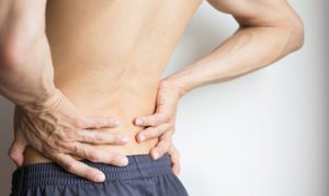 A person with their hands on his back