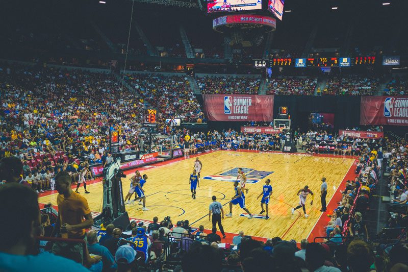 A group of people playing basketball on an indoor court.