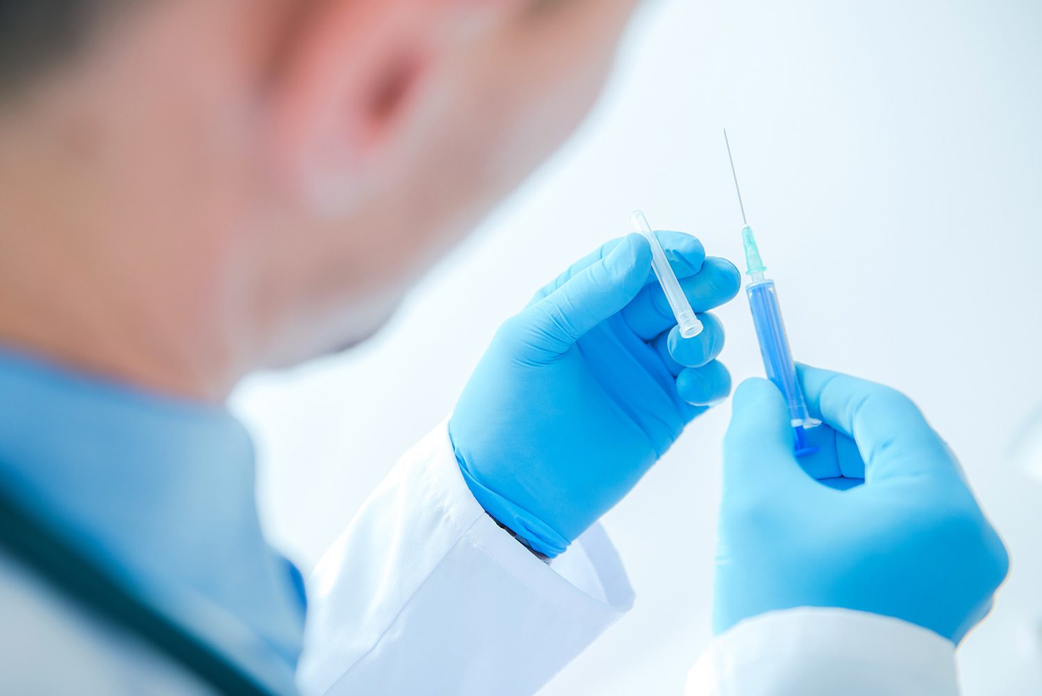 A person holding a syringe in his hand.