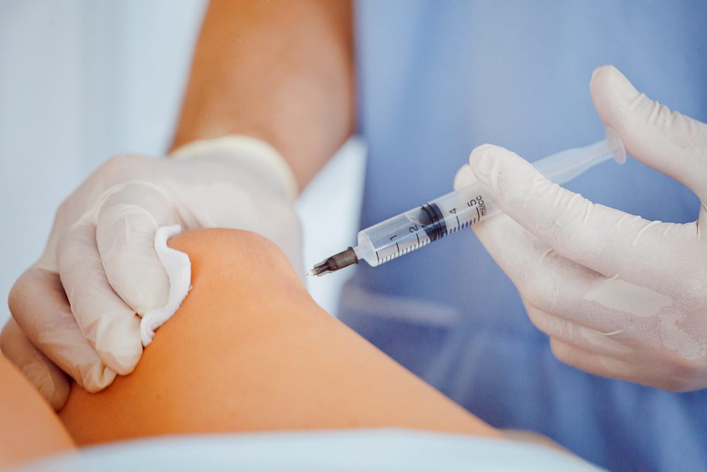 A person is holding an injection in their hand.