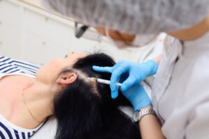 A woman getting her hair cut by an esthetician.