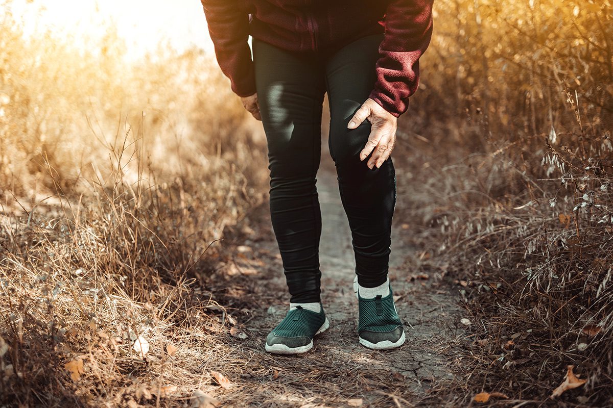 A person standing on top of a dirt road.