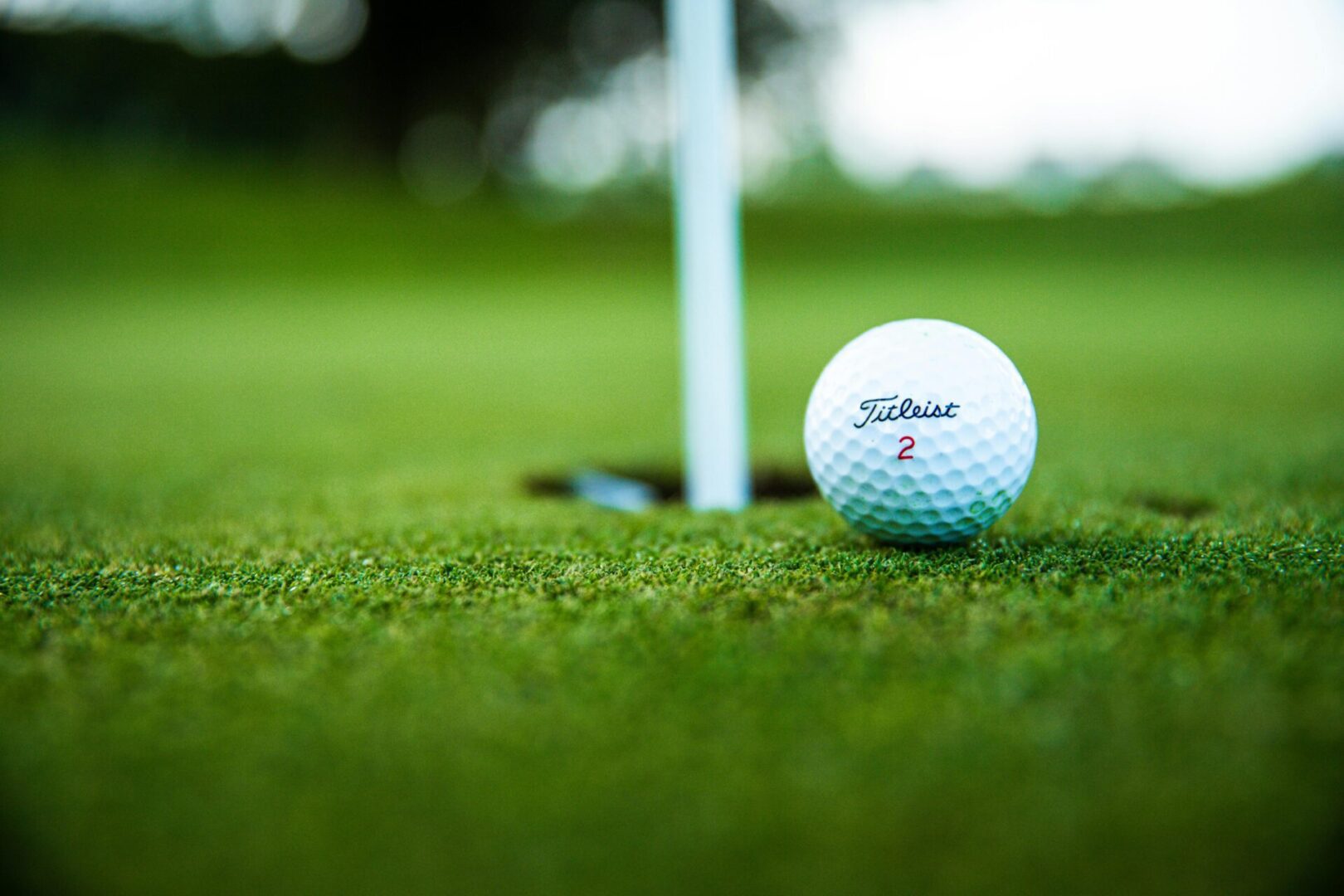 A close up of a golf ball near the hole