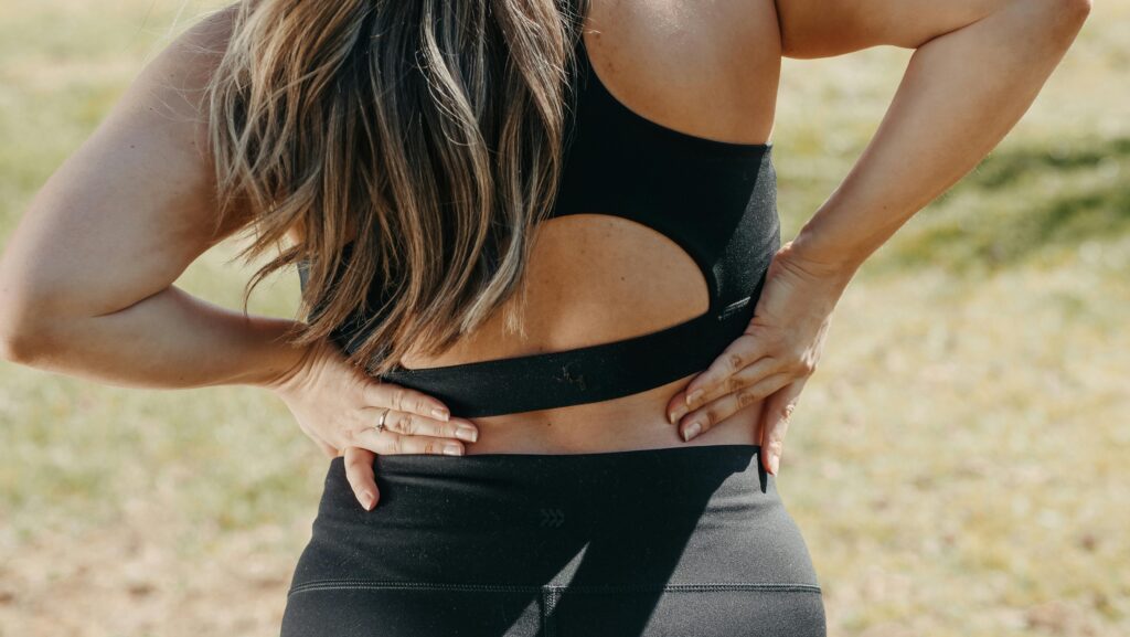 Epidural Steroid Injections for Back Injuries in Sports Regenerative Medicine & Orthopedics Miami Woman in black workout clothes with back pain.