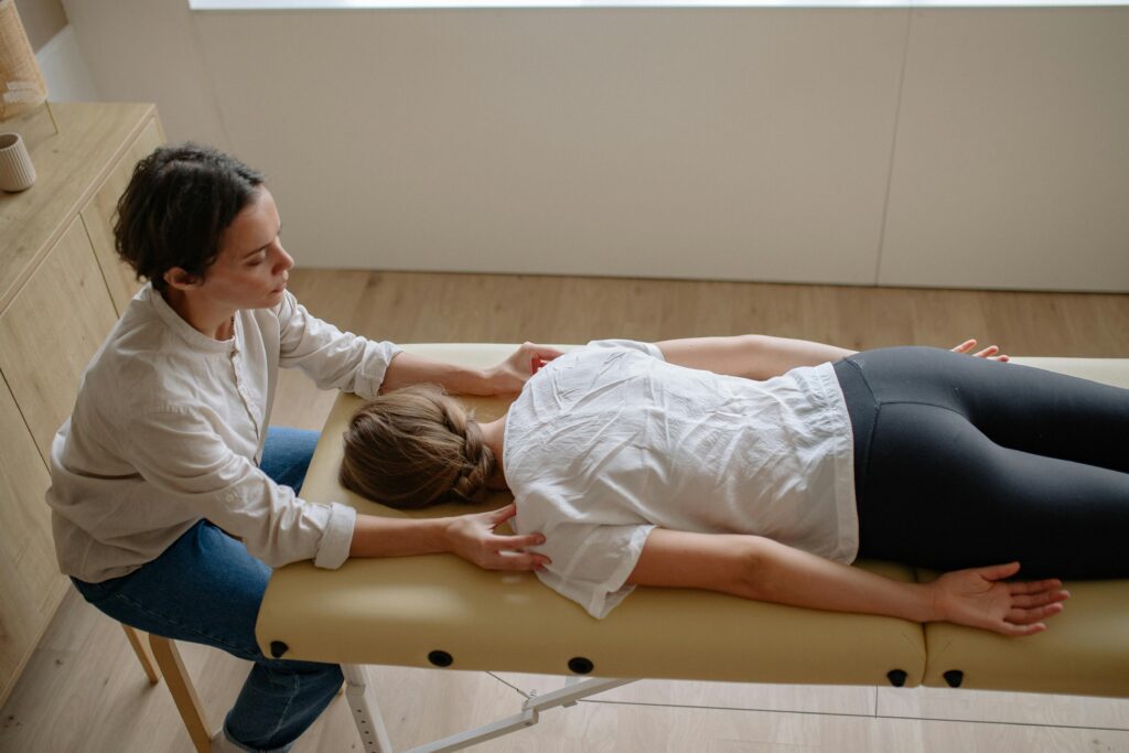 Person receiving neck massage on treatment table